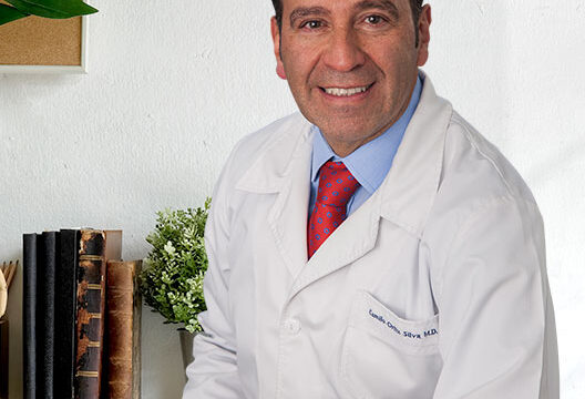 Handsome smiling medicine doctor sitting in office